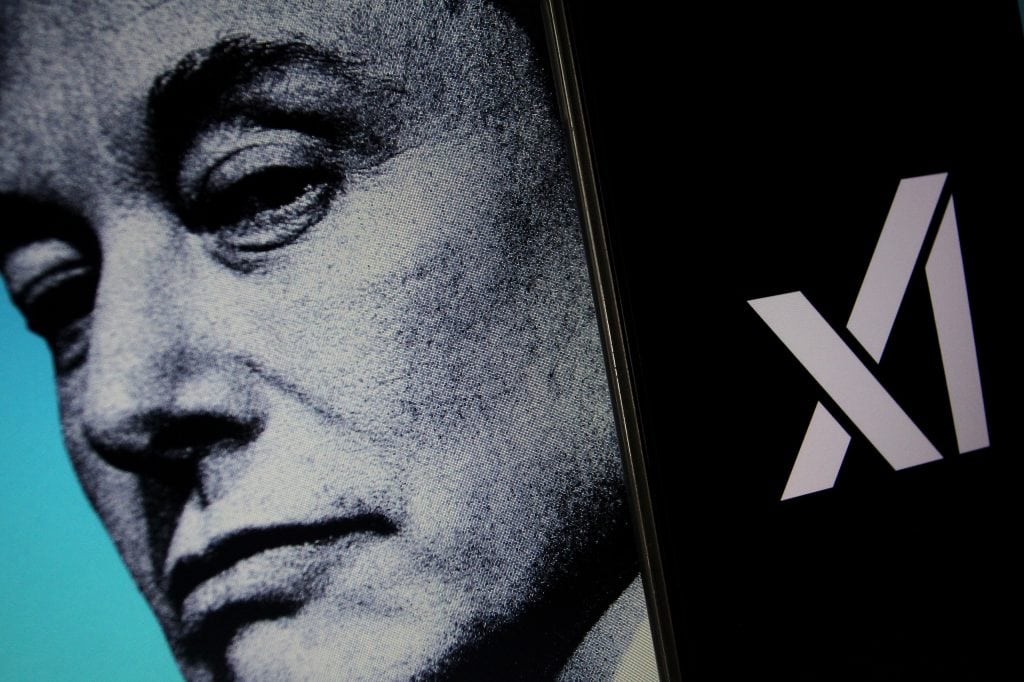 Rosto preto e branco de Elon Musk ao lado do logo da xAI exibido em um smartphone